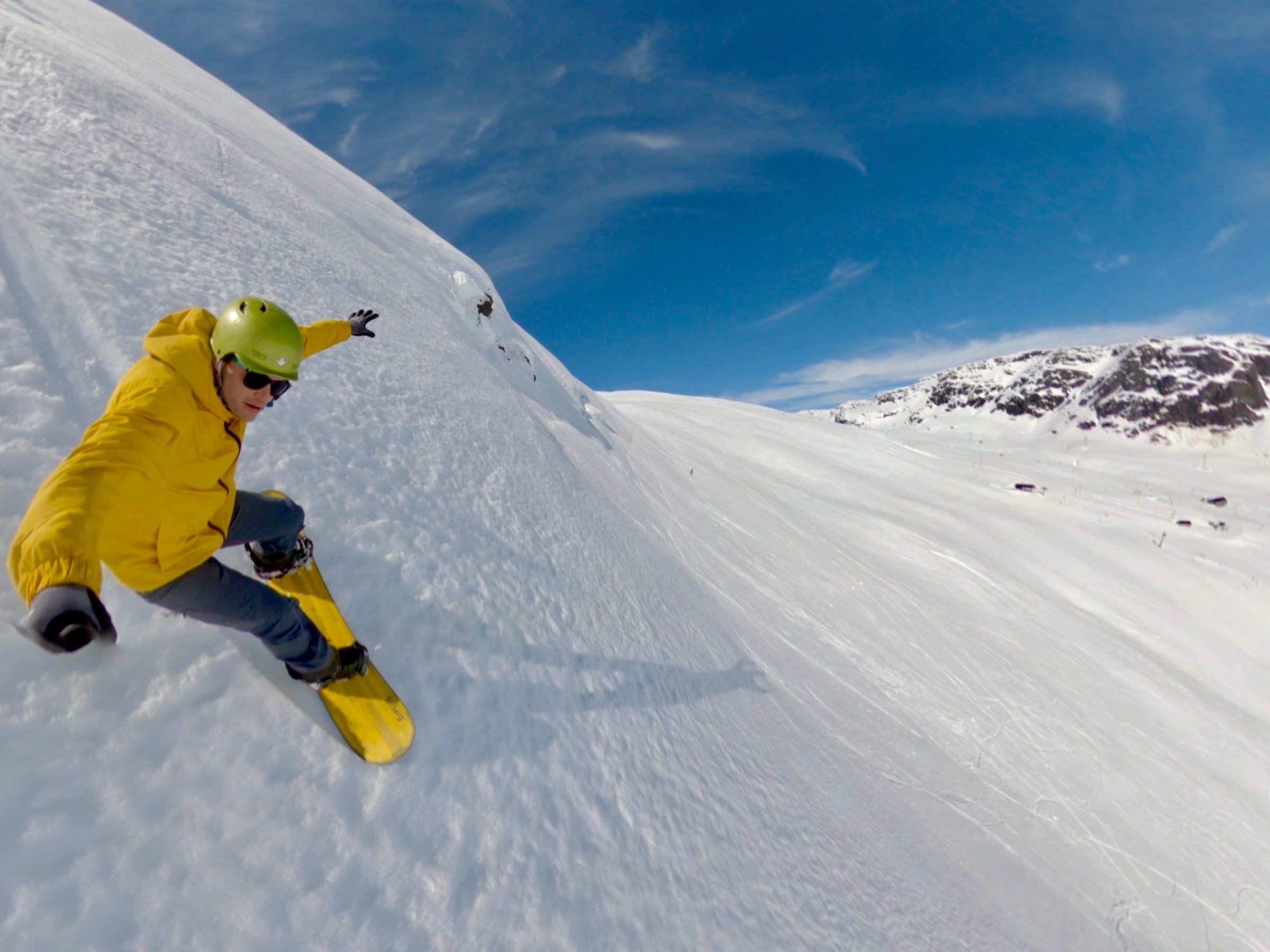 a man riding a snowboard down a snow covered slope